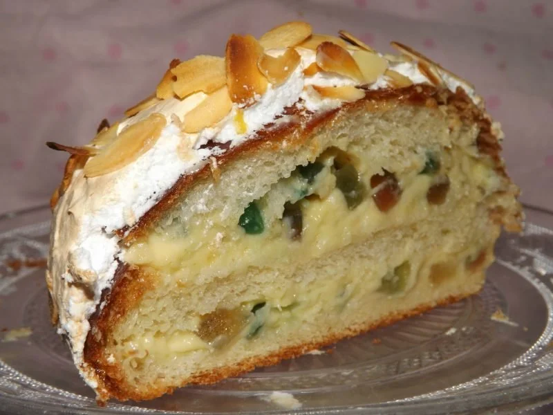 Brioche Bolonaise con frutti canditi e meringa italiana in un piatto elegante.