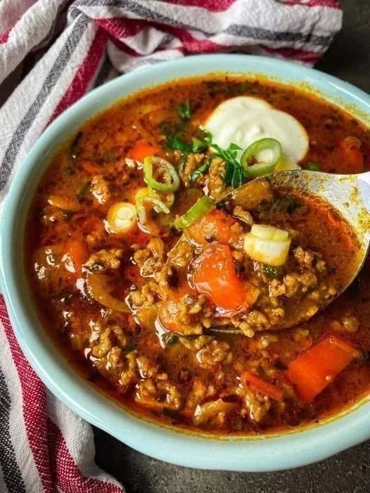 Bowl of Cheesy Keto Taco Soup garnished with cheese and avocado