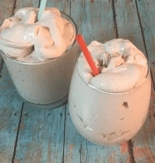 Homemade chocolate frosty in a cup with a straw
