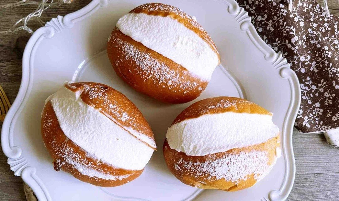Maritozzi alla crema serviti su un piatto, morbidi e invitanti.
