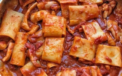 Piatto di calamarata con calamari fresco e aromi mediterranei