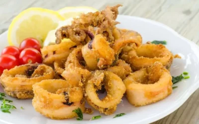 Calamars frits croccanti serviti con salsa di accompagnamento.