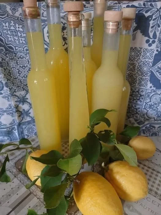 Bottiglia di limoncello artigianale con limoni freschi