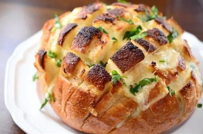 Pane riccio all'aglio e mozzarella su un piatto bianco