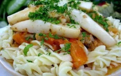 Pasta ai calamari e gamberetti servita con una salsa deliziosa.
