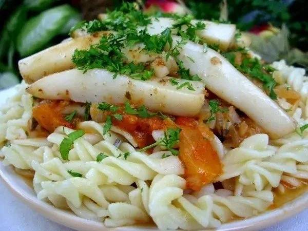 Pasta ai calamari e gamberetti servita con una salsa deliziosa.