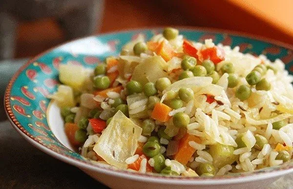 Piatto di riso con verdure fresche e spezie aromatiche.