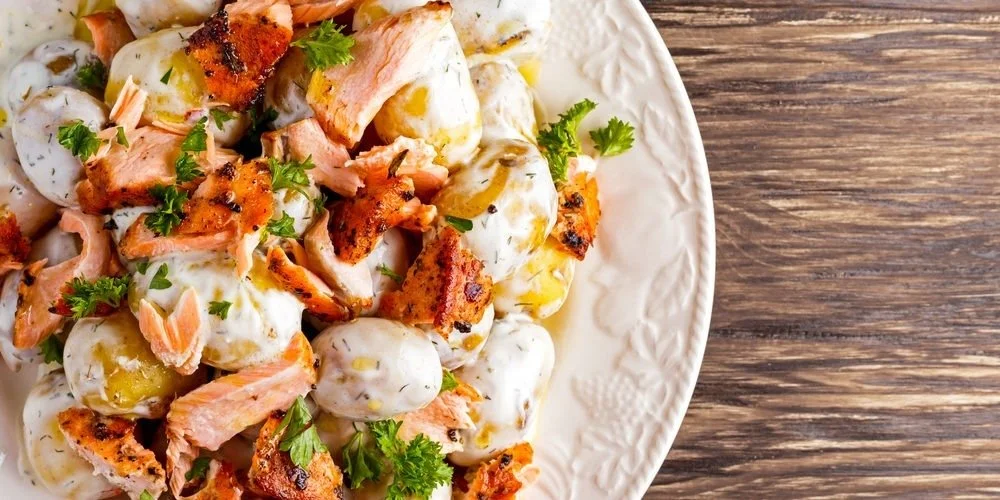 Smoked salmon potato salad served in a bowl with fresh herbs