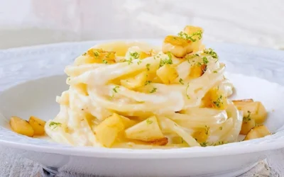 Tonnarelli alle mele croccanti e pecorino serviti in un piatto