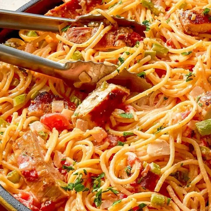 Bowl of Cajun Chicken Spaghetti topped with creamy sauce and fresh herbs