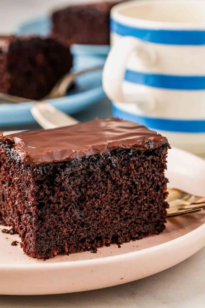 Slice of Depression Cake on a plate with frosting and a fork