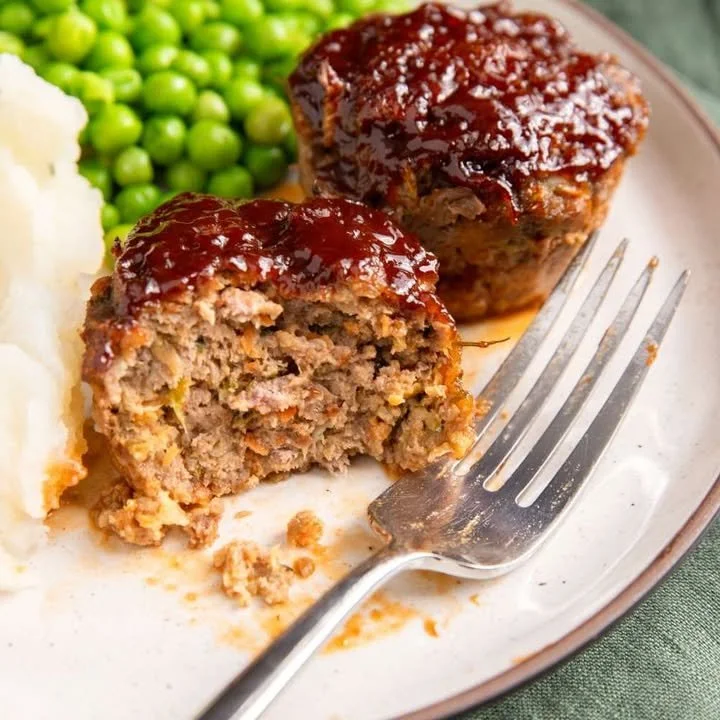Deliciously baked meatloaf muffins served with a side of vegetables.