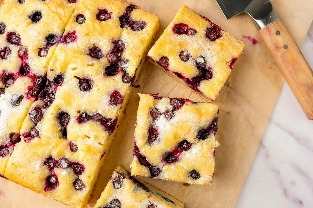 Delicious sheet cake topped with fresh blueberries on a serving plate
